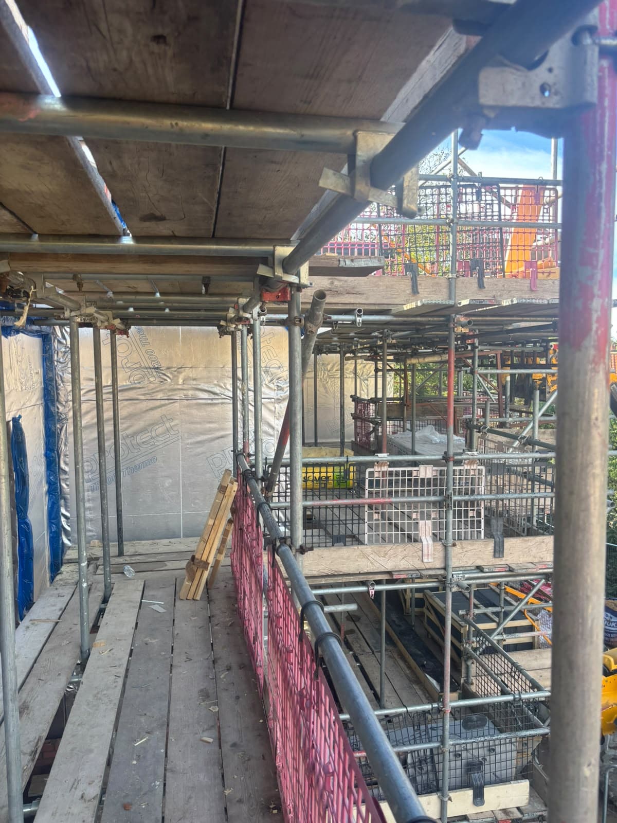 Scaffold walkway alongside wrapped timber wall panels